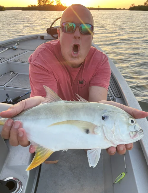 Silver inshore fish held on a fishing boat at sunset