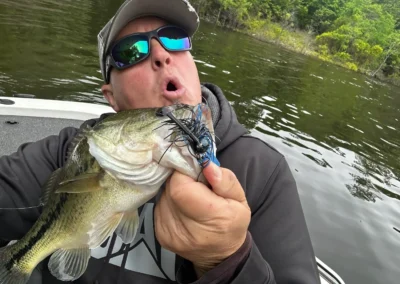 Mike Boyles is holding a bass on a fishing boat
