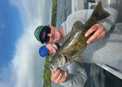 Angler holding a largemouth bass on a calm lake