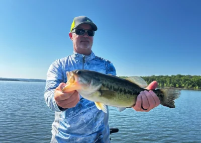 Angler holding a largemouth bass during a lake fishing trip