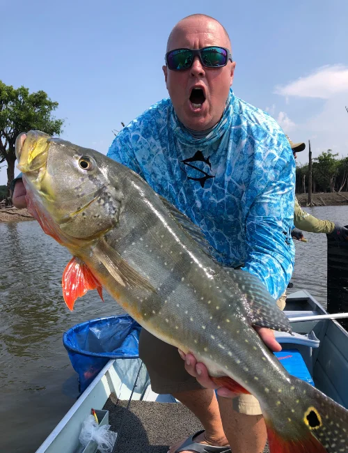 Captain Mike Boyles holding a bass on a fishing boat