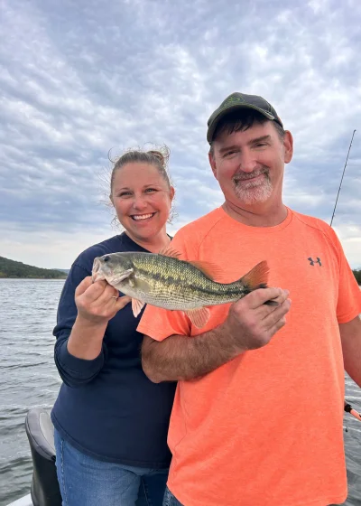 A couple holding a bass on a boat at Table Rock Lake