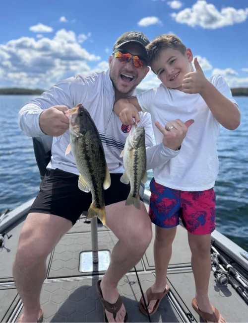 An adult and child holding bass on a boat at Table Rock Lake